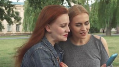 Telefon paylaşırken konuşurken ang gülümseyen kız