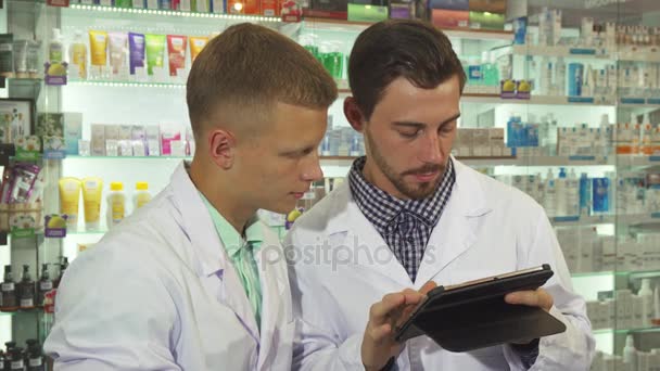 Zwei Apotheker mit Tablette bei der Arbeit — Stockvideo