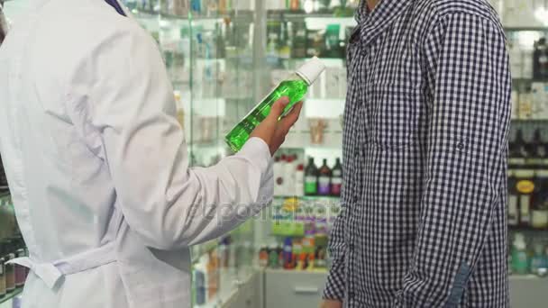 Лікар дає пляшку миття рота пацієнту і трясе руки — стокове відео