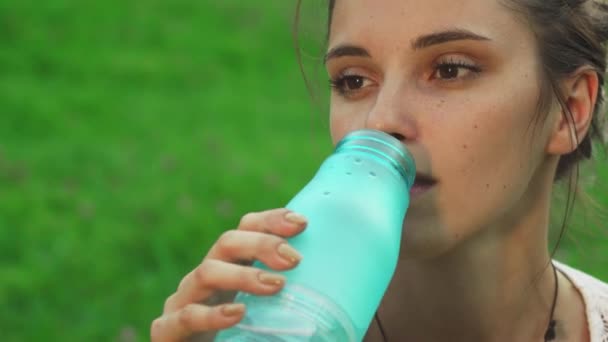 Красивая девушка пьет воду, занимаясь йогой — стоковое видео