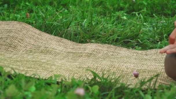 O tapete de ioga está deitado na grama — Vídeo de Stock