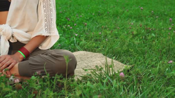 Den unga damen sitter på mattan och göra yoga — Stockvideo