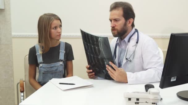 El médico le está mostrando al paciente su radiografía. — Vídeo de stock