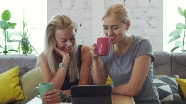 İki kız tablette bir şey izliyor