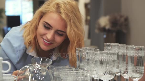 La ragazza sta scegliendo nuovi bicchieri da vino per la casa — Video Stock