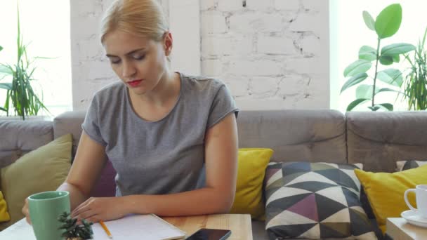 La ragazza sta bevendo caffè e scrivendo un abstract — Video Stock