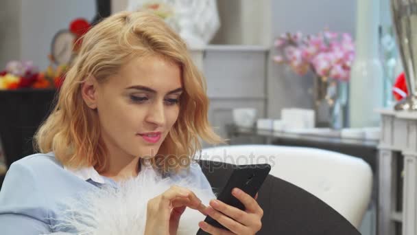 A menina está olhando para algo em seu telefone celular — Vídeo de Stock