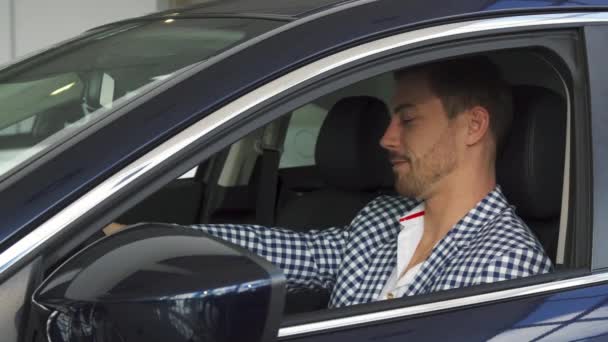 De stevige man zit in zijn nieuwe auto — Stockvideo