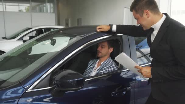 Der Autohändler interessiert sich für die Eindrücke der Käufer — Stockvideo