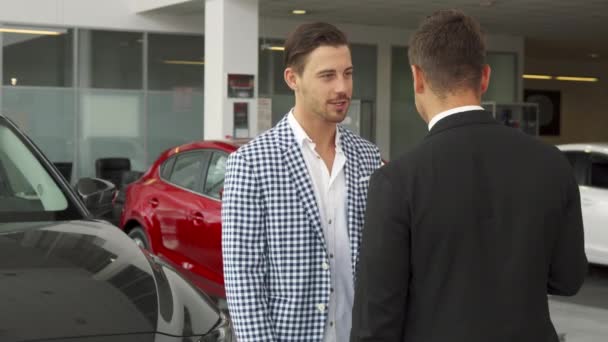 Η ευτυχής αγοραστής και ο πωλητής κάνει μια διαπραγμάτευση για να αγοράσει ένα αυτοκίνητο — Αρχείο Βίντεο