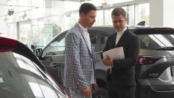 Los hombres serios firman un contrato de compra de coche — Vídeos de Stock