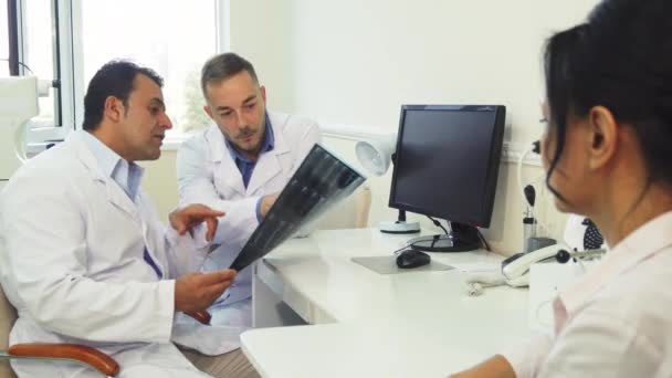 Les médecins examinent la radiographie alors qu'ils sont assis dans le bureau — Video