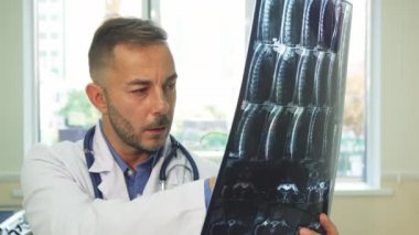 Gülümseyen Doktor Röntgen fotoğrafını inceleyerek
