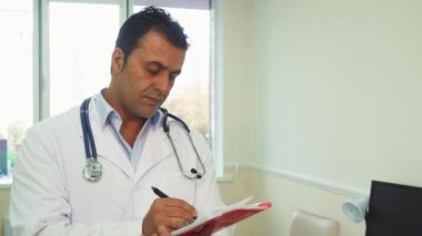Akıllı doktor notlar onun not defterinde yapıyor.