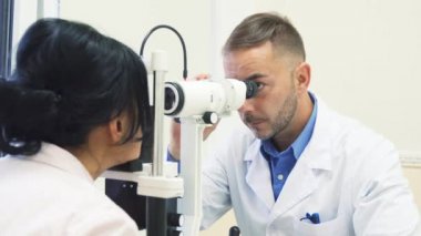 Dikkatli göz doktoru onun hasta gözleri inceliyor