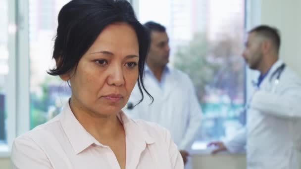 A sad patient is standing next to the doctors in the office — Stock Video