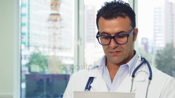 Doctor en gafas examina cuidadosamente el papel — Vídeos de Stock