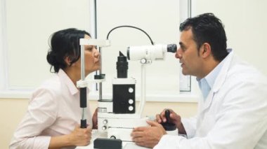 Yetenekli bir doktor hasta gözleri olan bir cihaz inceliyor.