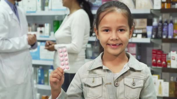 Niña sosteniendo la medicina y mostrando los pulgares hacia arriba — Vídeo de stock