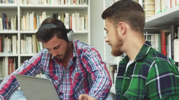 Dois caras bonitos passam seu tempo livre na biblioteca — Vídeo de Stock