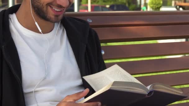 El hombre guapo da vuelta las páginas y lee el libro — Vídeos de Stock