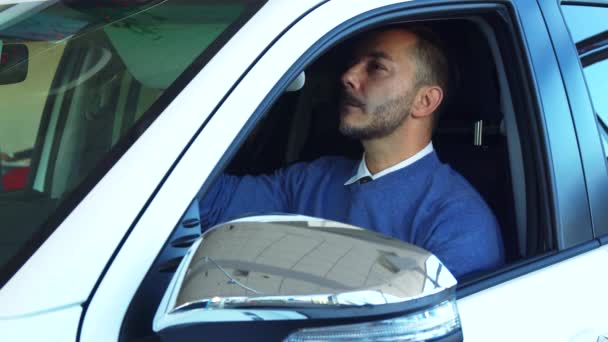 El hombre sonriente examina el interior del coche — Vídeo de stock