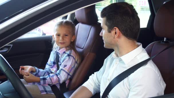 The young father communicates with the daughter sitting in the car — Stock Video
