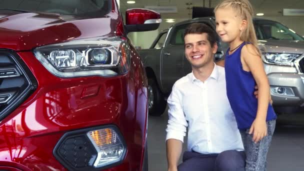 En ung far och dotter står nära en av bilarna — Stockvideo