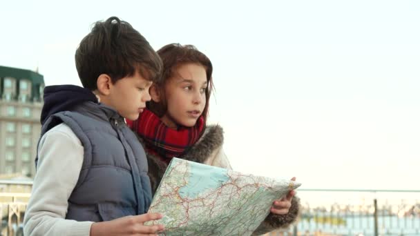 Menino e menina da escola encontraram um lugar de interesse com a ajuda do mapa — Vídeo de Stock