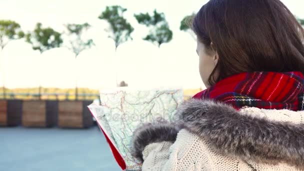 A menina está procurando a rota desejada no mapa — Vídeo de Stock