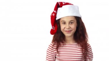 Bir Noel Baba şapkalı bir kız kameraya gülümsüyor