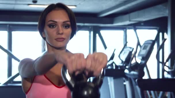 Спортивная девушка делает упражнения с тяжелыми гантелями — стоковое видео