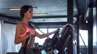 Genç bir kız yaklaşım elips simülatörü tamamlar