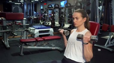 Çalışkan kız kollarını dumbbells ile eğitim