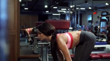 Güzel kız bir halter ile ileri virajlı elinde gerçekleştirir.