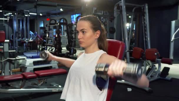 Спортсменка накачує м'язи рук — стокове відео