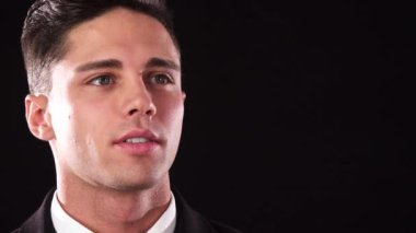 Yakışıklı bir adam dalgın görünüyor ve kameraya gülümsüyor