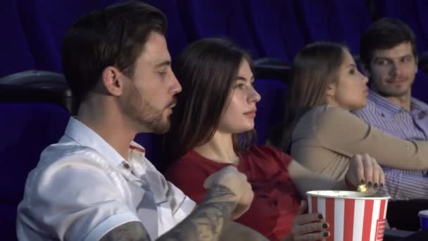 Dos parejas jóvenes viendo el estreno de una nueva película — Vídeo de stock