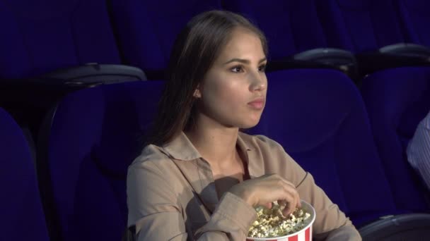 La chica muestra un signo de silencio sentado en la sala de cine — Vídeos de Stock