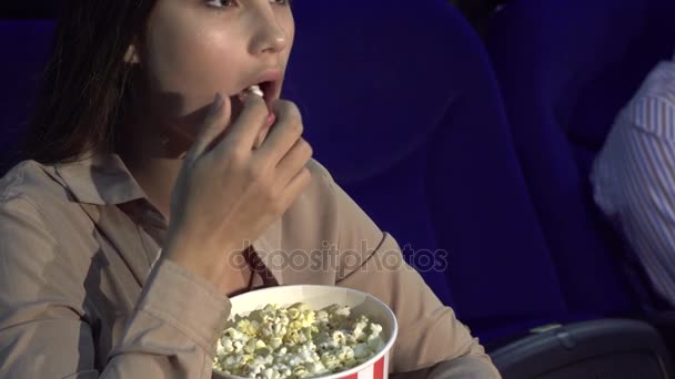 Un primo piano di come una ragazza mangia popcorn e mostra un segno di silenzio — Video Stock