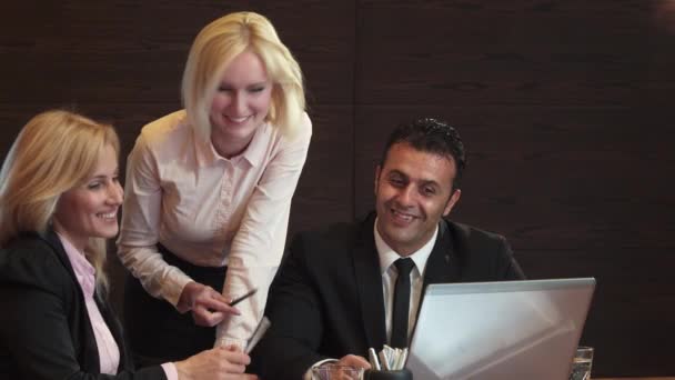 Três pessoas de negócios estão discutindo ativamente o que vêem em seu laptop — Vídeo de Stock