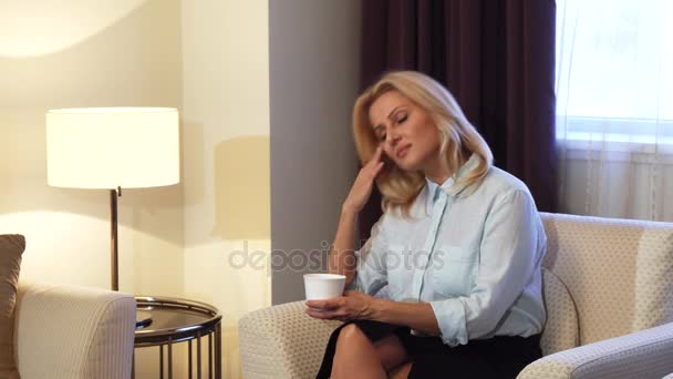 Chica cansada sentada en la silla y tomando café — Vídeos de Stock
