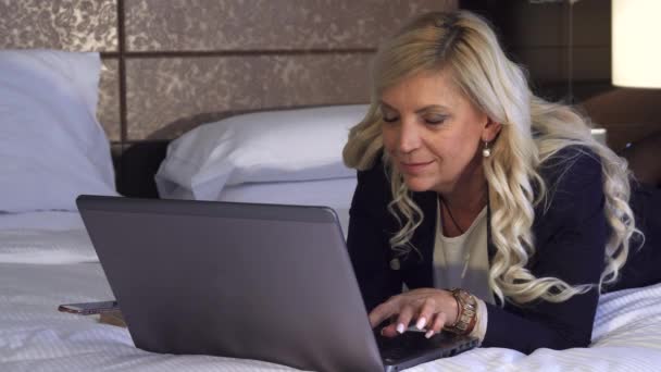 Mooie vrouw op zoek naar informatie in haar laptop — Stockvideo