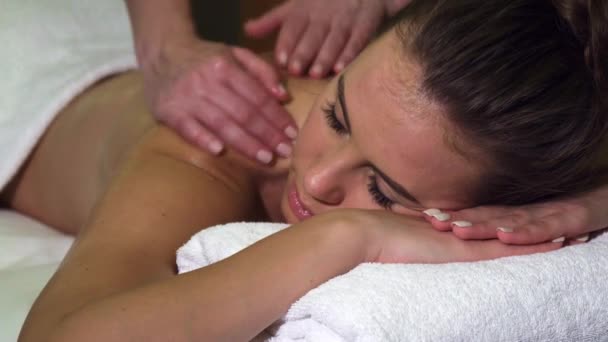 Nahaufnahme von Gesicht und Rücken eines Mädchens, das eine Rückenmassage im Wellness-Salon hat — Stockvideo