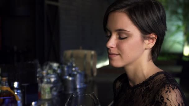 Close up de uma linda morena gostando de beber vinho no bar sorrindo para a câmera — Vídeo de Stock