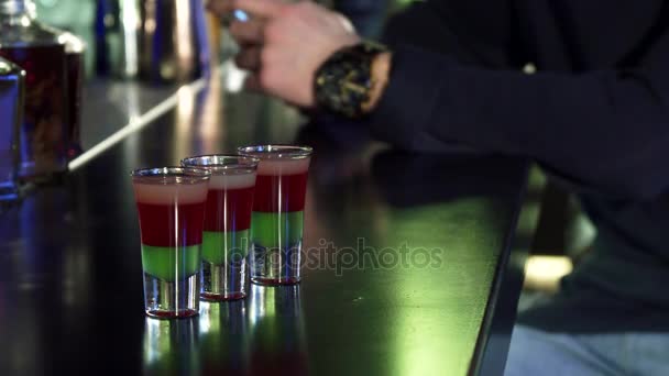 Selective focus on three shots on the bar table man using his smart phone on the background — Stock Video