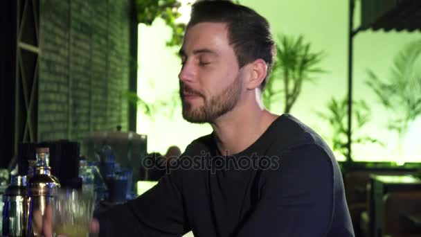 Guapo joven barbudo alegre bebiendo en el bar local — Vídeos de Stock