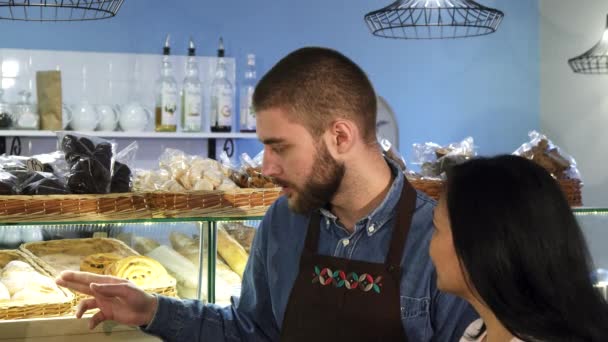 Professionele mannelijke baker werken bij zijn winkel helpen zijn volwassen vrouwelijke klant — Stockvideo