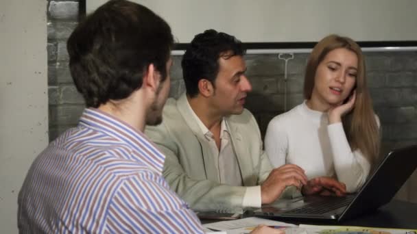Knappe jonge zakenman glimlachen naar de camera tijdens zakelijke bijeenkomst — Stockvideo