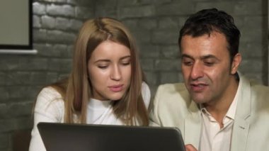 Olgun işadamı ve genç meslektaşı dizüstü bilgisayarda çalışma